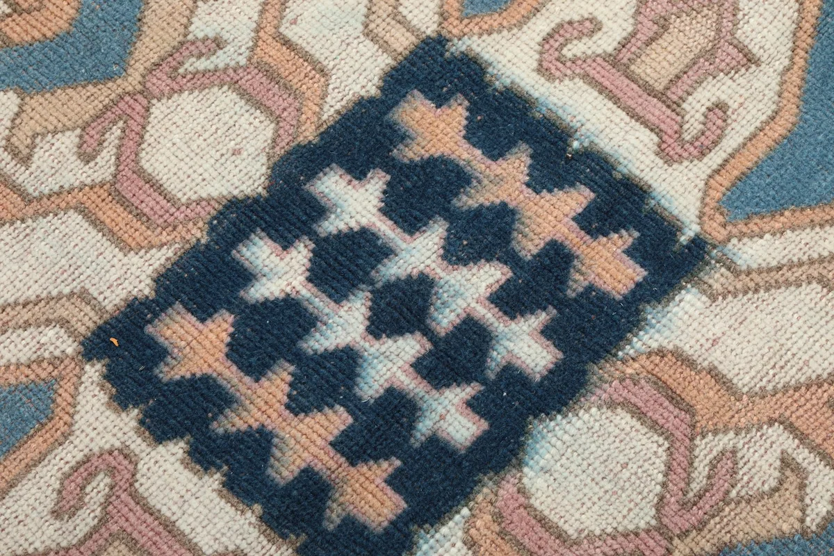 Macro detail of the hand-knotted wool pile and intricate patterns within the central medallion.