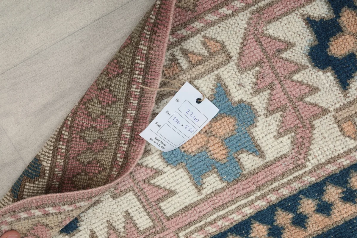 View of the rug's label attached to the back, indicating its origin and material details.