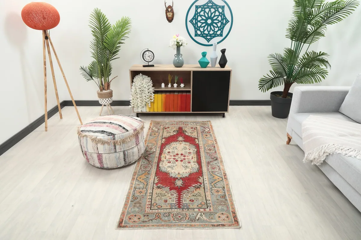 Vintage Anatolian rug displayed in a living room setting with a sofa and ottoman