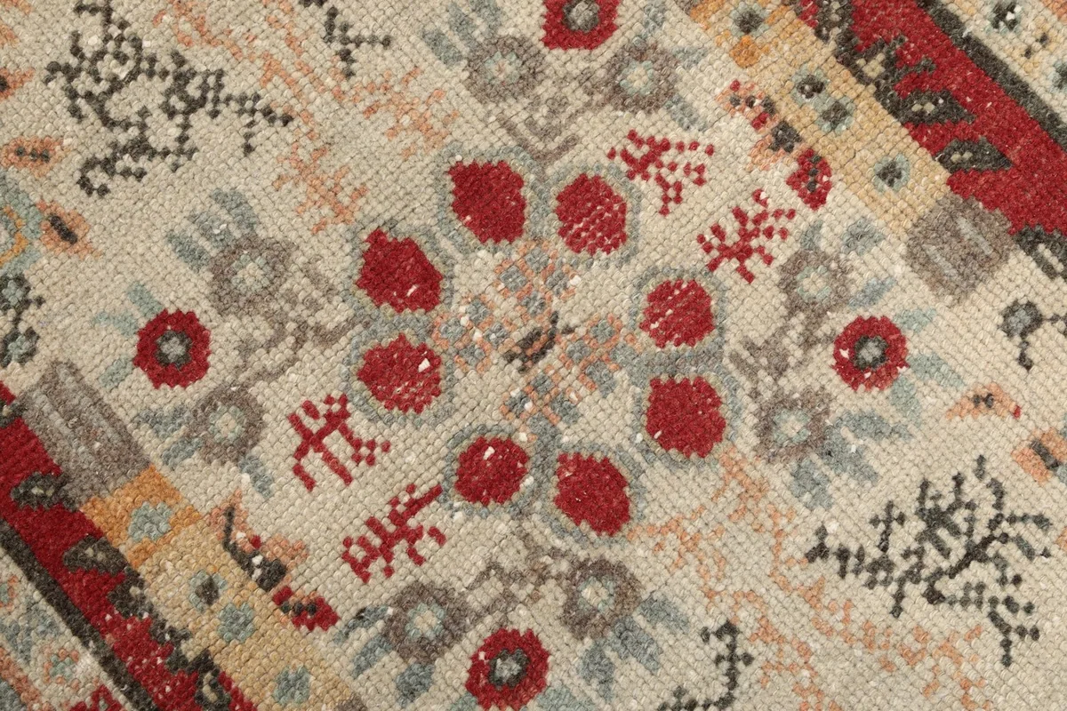 Close-up of the intricate tribal patterns and colors within the rug's central field