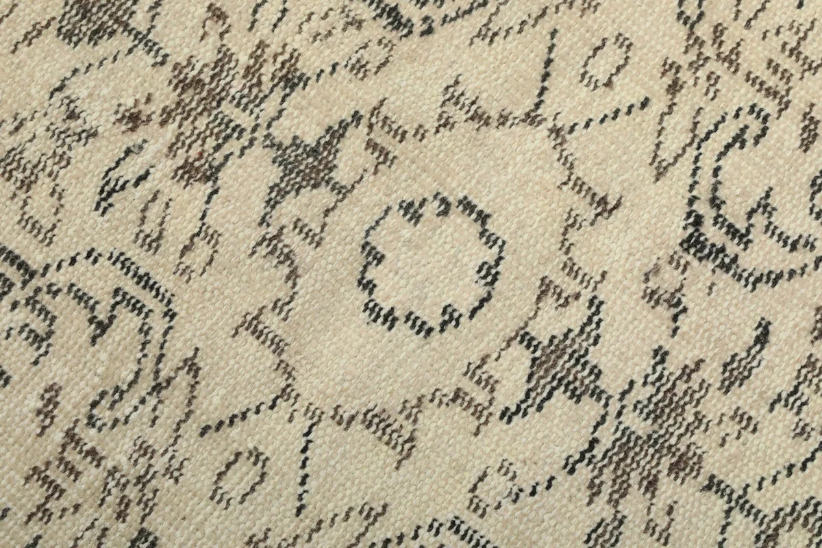 Texture and low pile of the hand-knotted wool rug, showing color variations