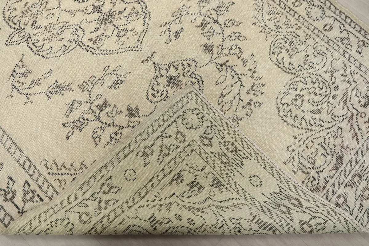 Corner of the rug folded back to reveal the cotton foundation and knotting