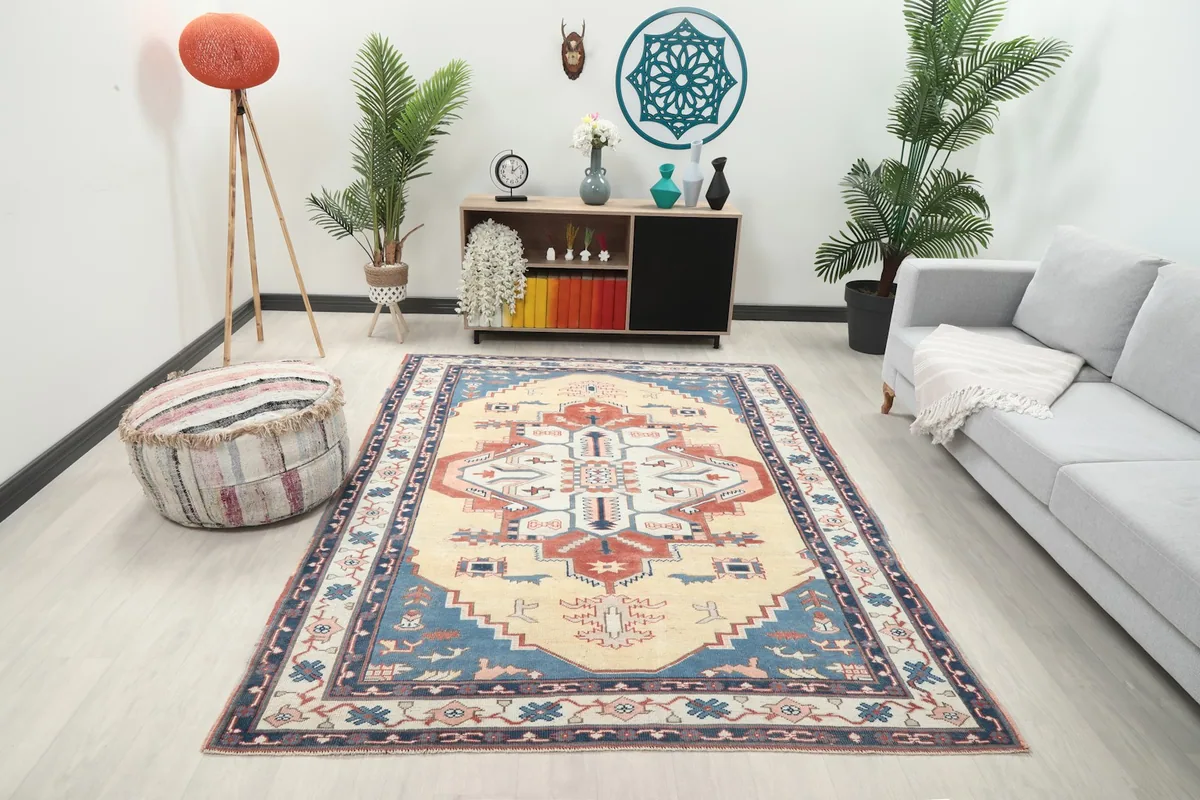 Vintage Anatolian rug displayed in a living room setting with a light gray sofa and wooden furniture