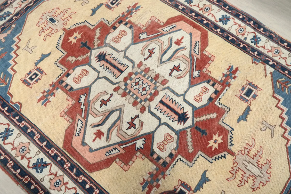 Close-up of the intricate central medallion, highlighting the rust, rose, and ivory colors and geometric shapes