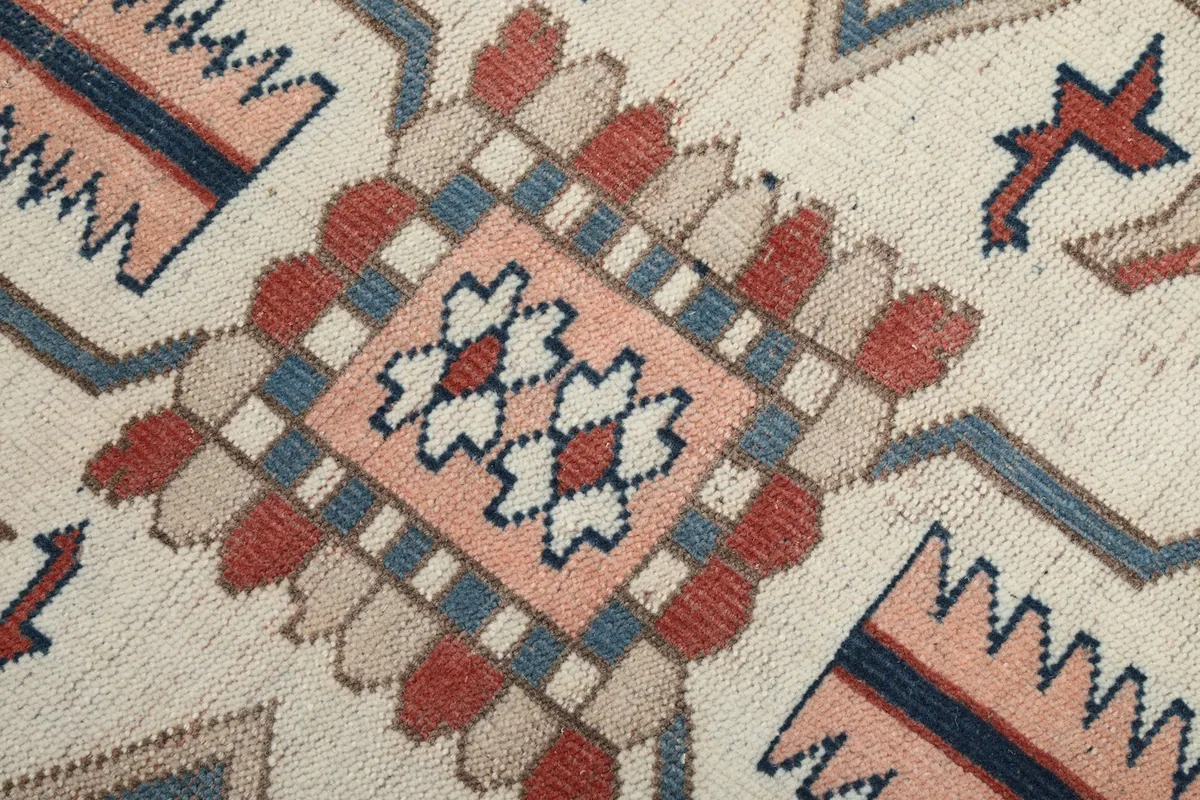 Very close detail of the hand-knotted wool pile and specific tribal elements within the medallion