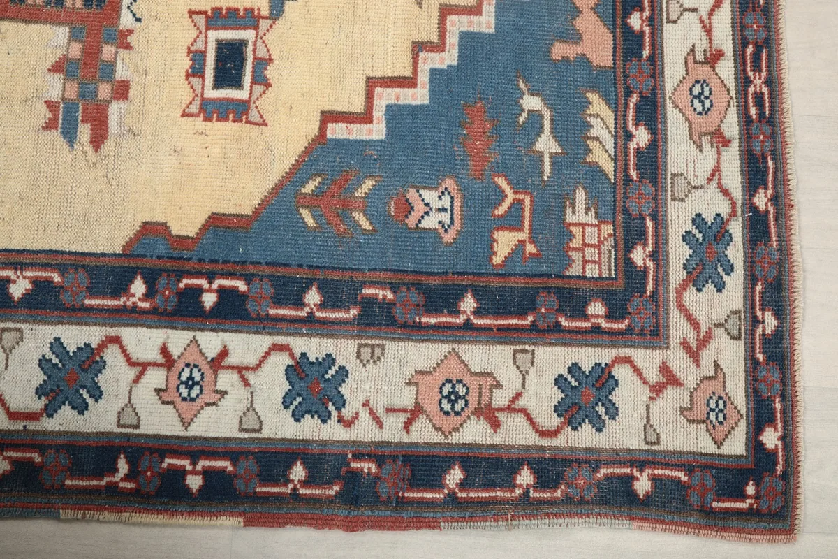 Detail of the blue border with geometric motifs and the corner design of the vintage rug