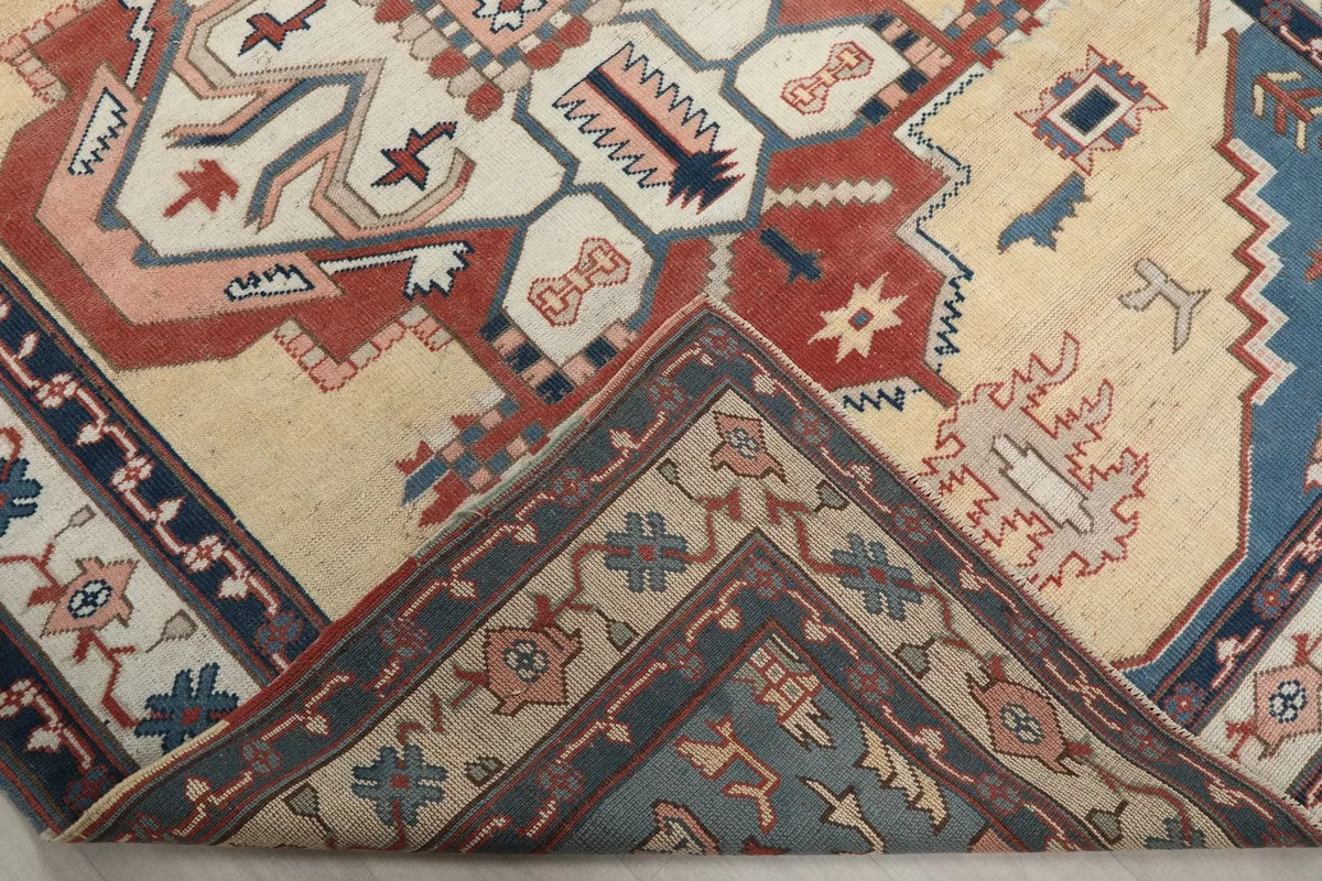Folded corner of the rug, revealing the back of the hand-knotted cotton foundation and wool pile
