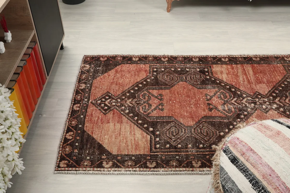 Angled view of the runner rug on the floor, capturing the interplay of rust and charcoal colors.