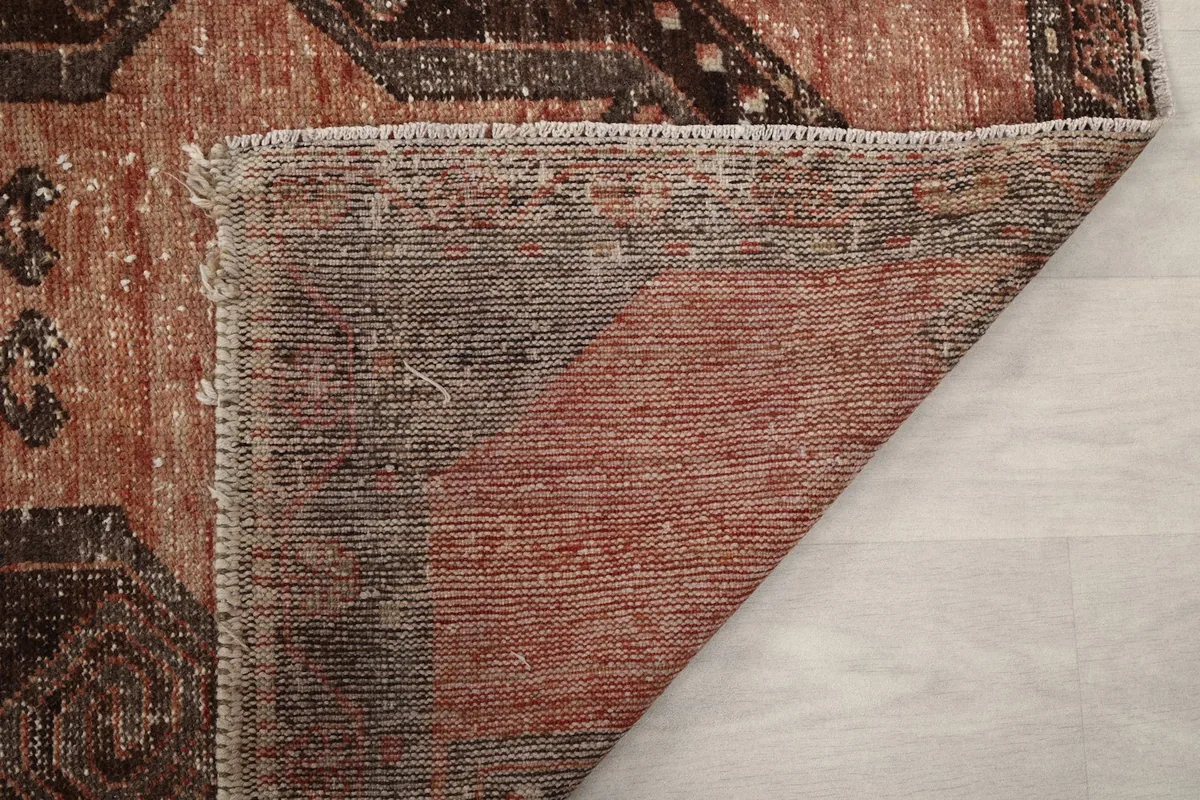 Detailed view of the reverse side of the rug, illustrating the construction of the wool pile on cotton.