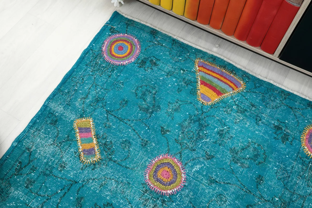 Corner view of the blue geometric rug, highlighting its unique design and subtle wear.