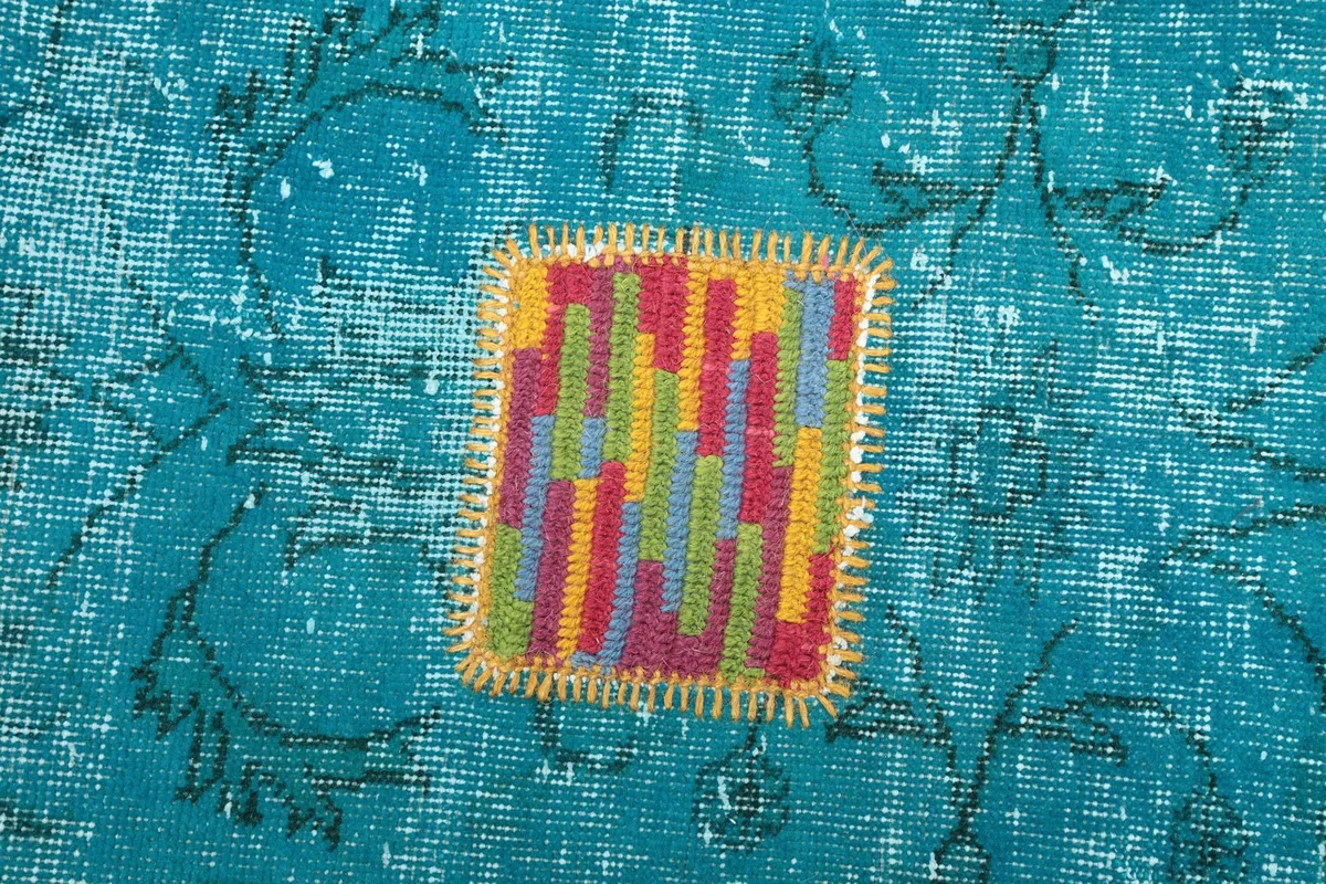Close-up of a square multicolor geometric motif with red, yellow, and green stripes.