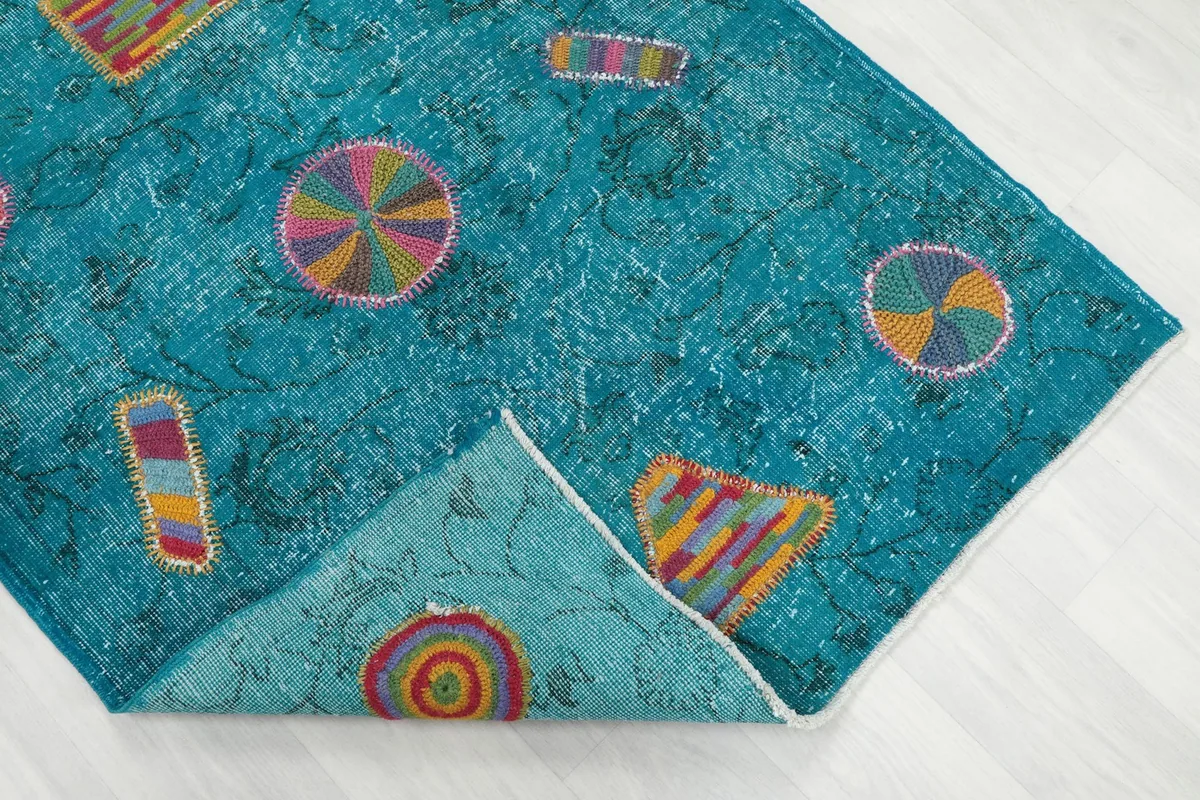 Corner of the rug folded back, showing the cotton foundation and the reverse side.
