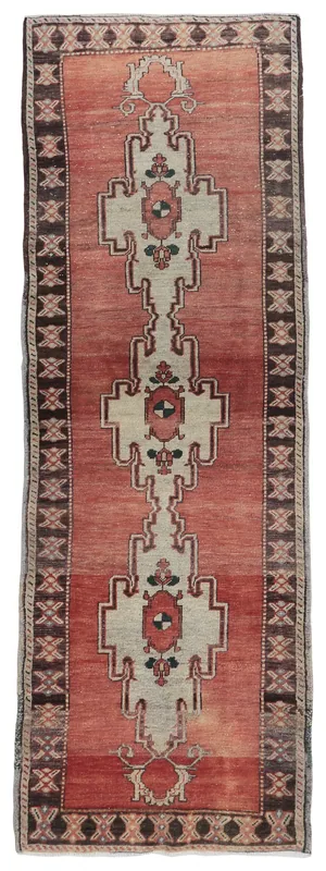 Full overhead view of a vintage rust and cream geometric Anatolian runner rug