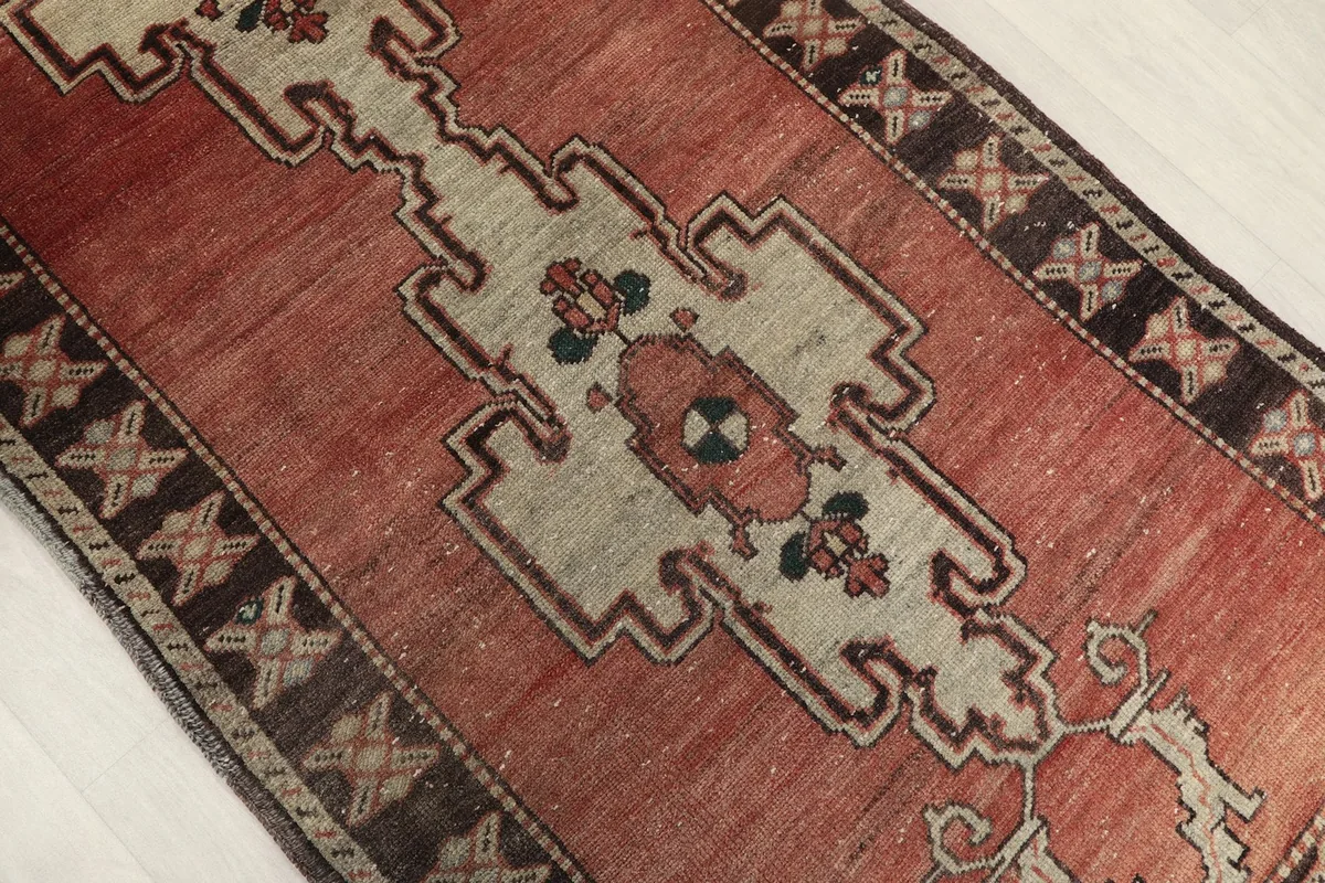 Upper-angle shot highlighting the cream geometric medallion and rust field