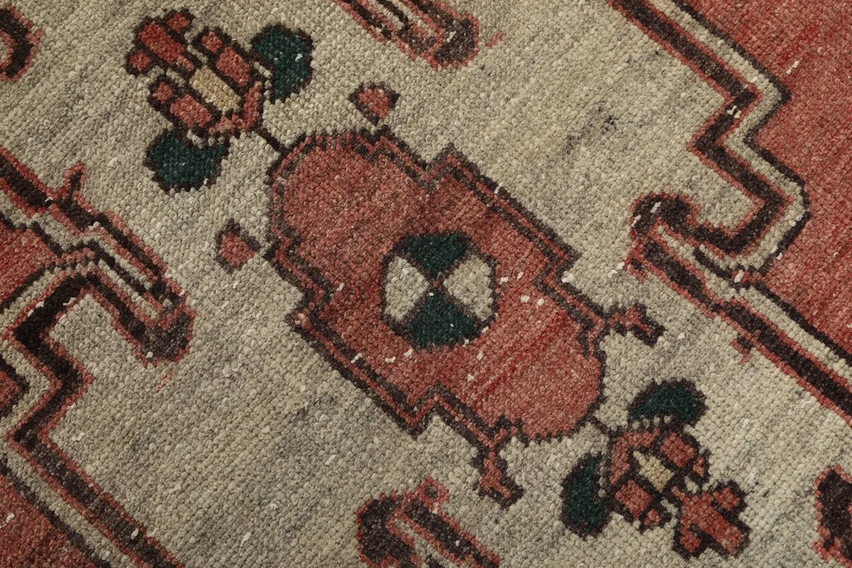 Macro detail of the central geometric motif with rust, cream, and green accents