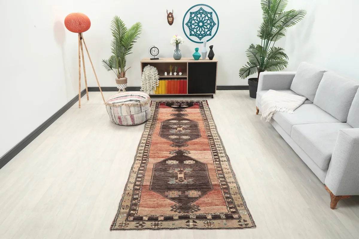 Vintage runner rug displayed in a modern hallway with a white sofa and green plants.