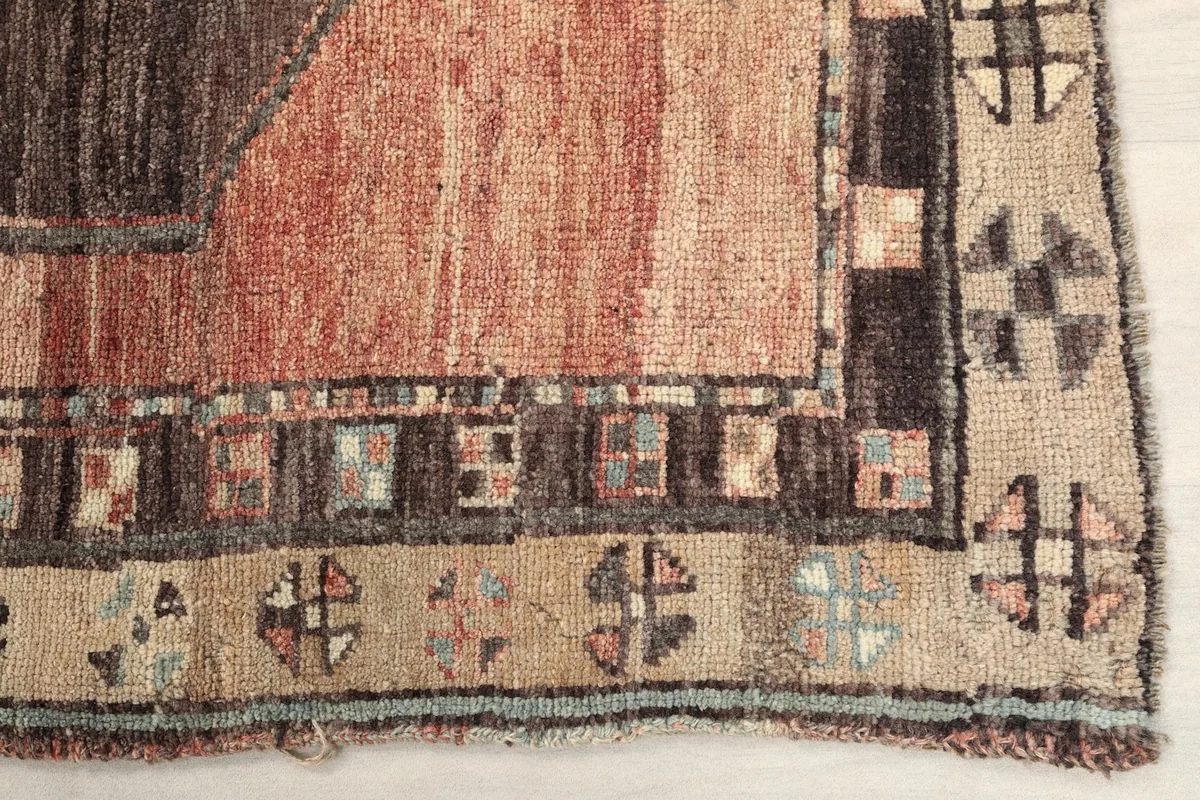 Detailed view of the rug's border with cream and beige tones and geometric motifs.