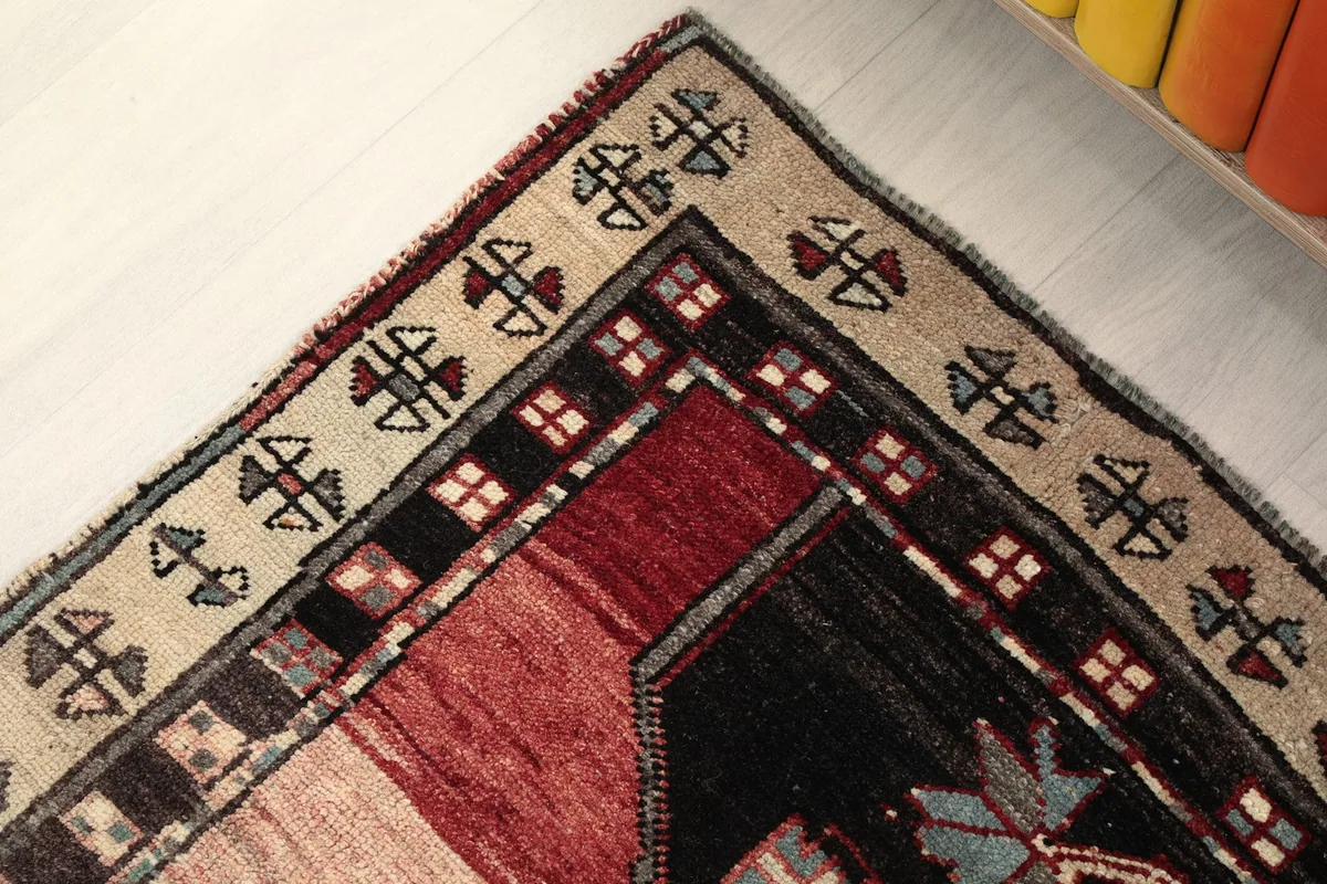 Corner detail of the rug, showing the cream border and the intricate patterns at the end.