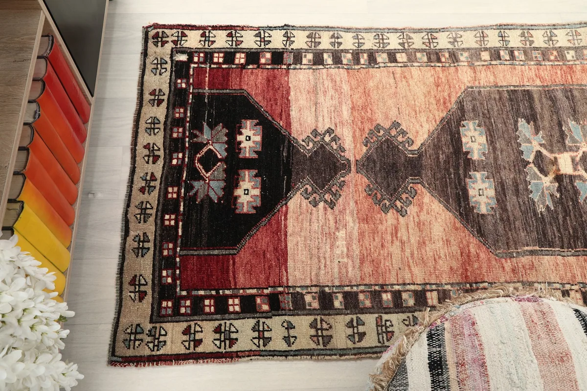 Overhead view focusing on the patterns and color variations of the rust and brown runner rug.