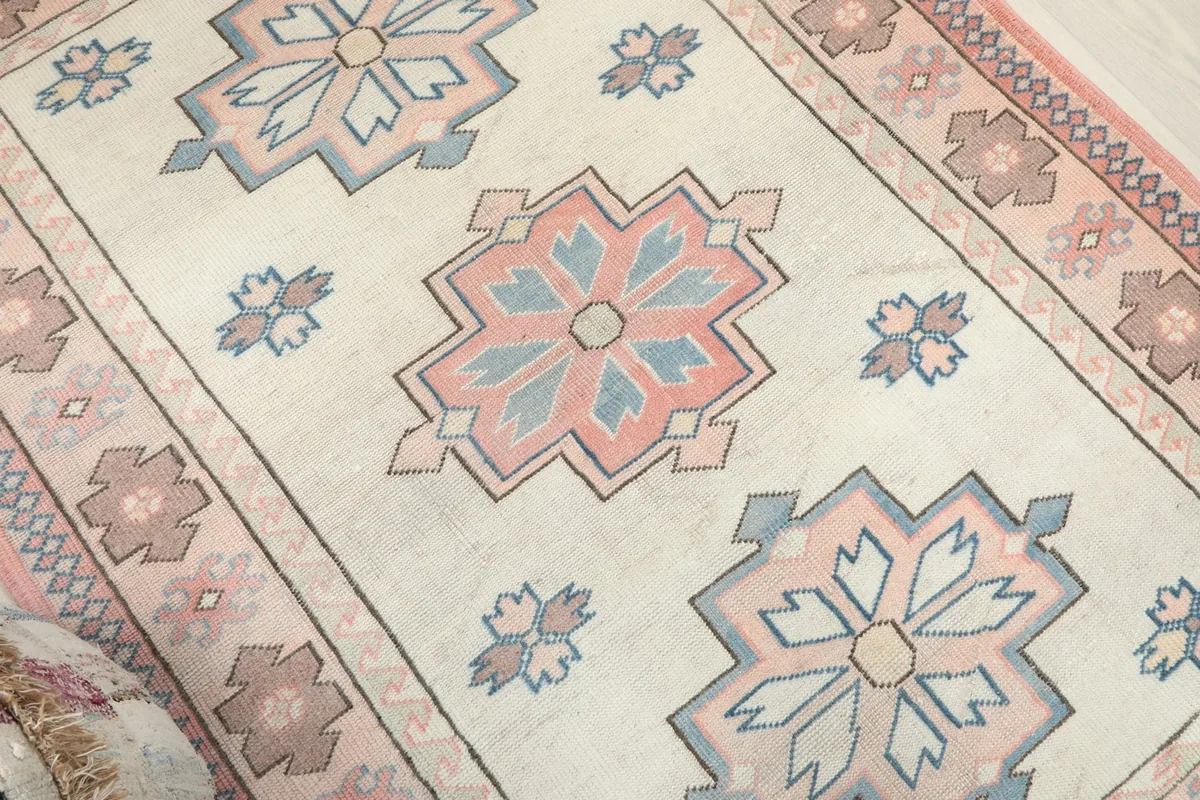 Angled view highlighting the vintage texture and colors of the rug's central motifs