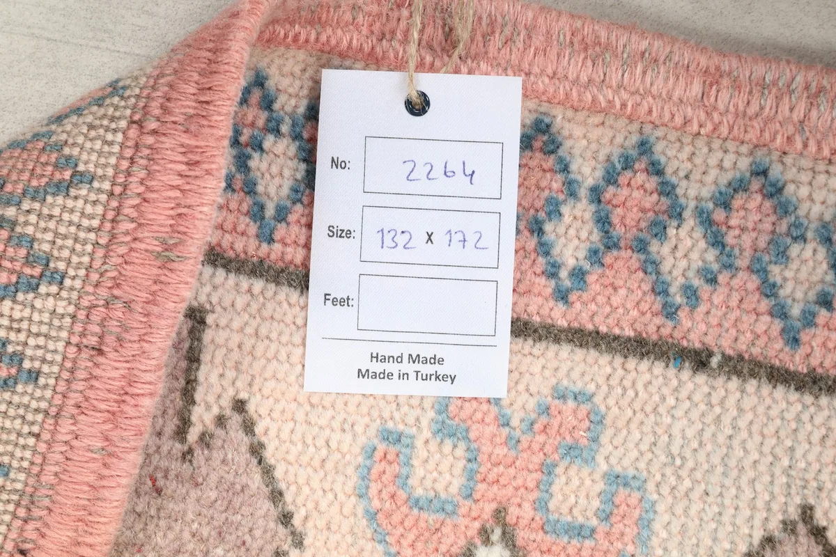 Back of the rug showing a tag with size and origin details, revealing the hand-knotted weave