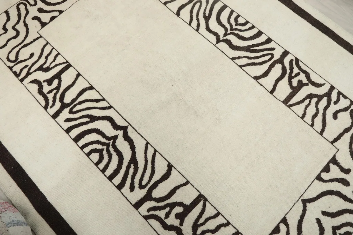 Close-up showing the texture of the cream pile and the charcoal wavy pattern