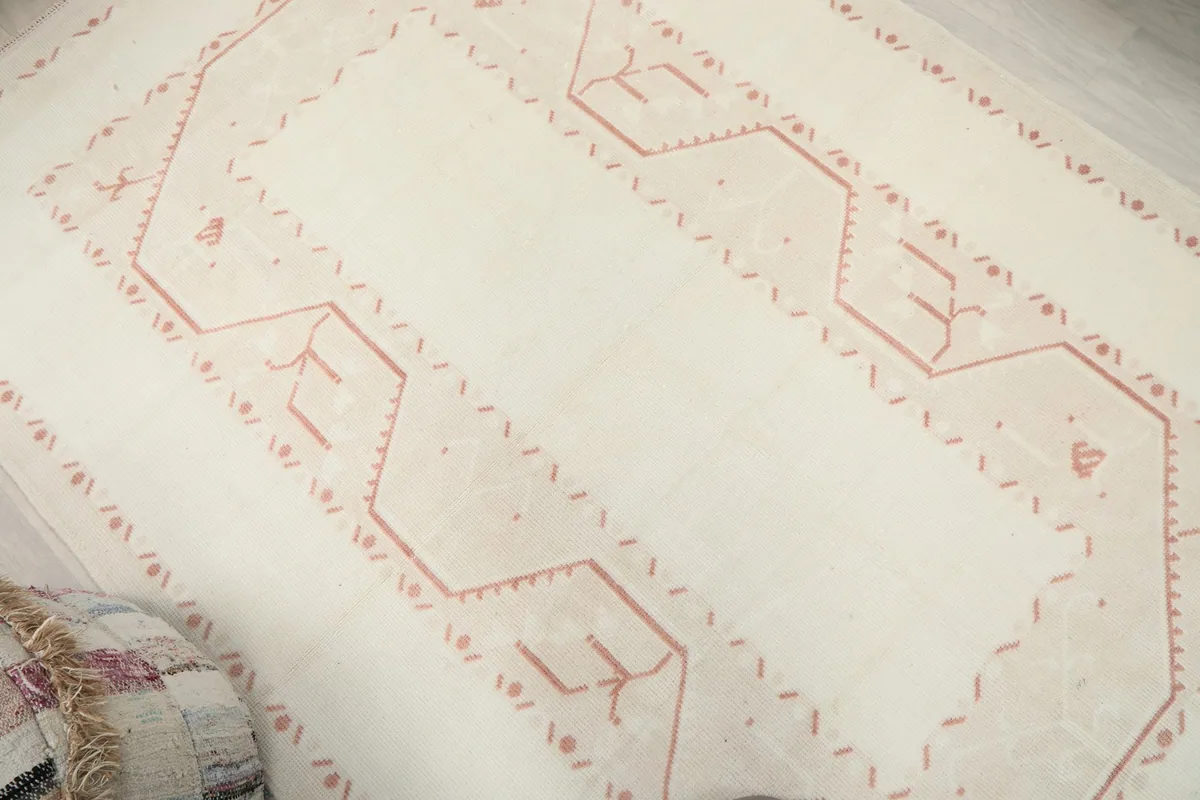 Overhead detail showing the subtle rose tribal motifs and texture of the rug