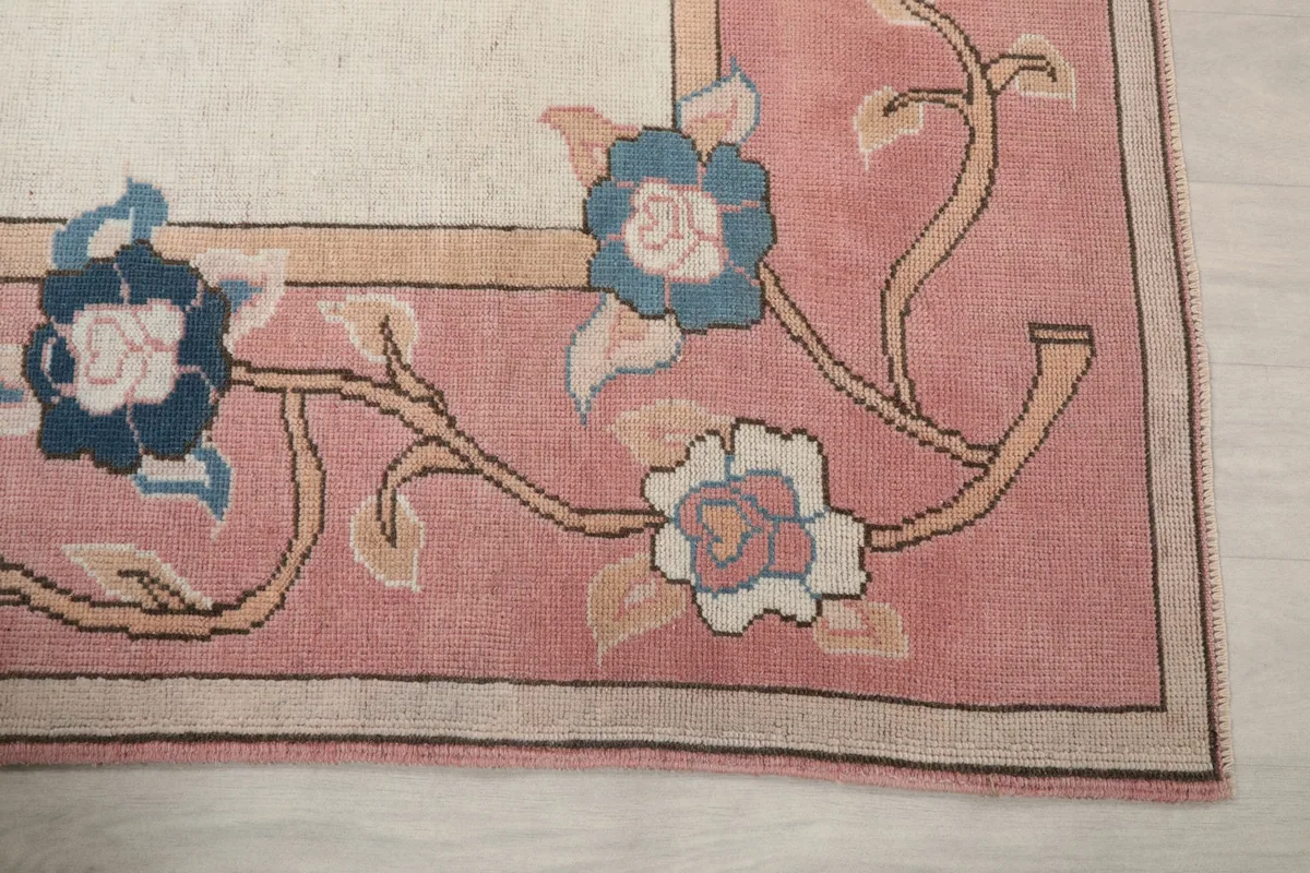Detailed view of the rose border with blue and ivory floral motifs and tan vines