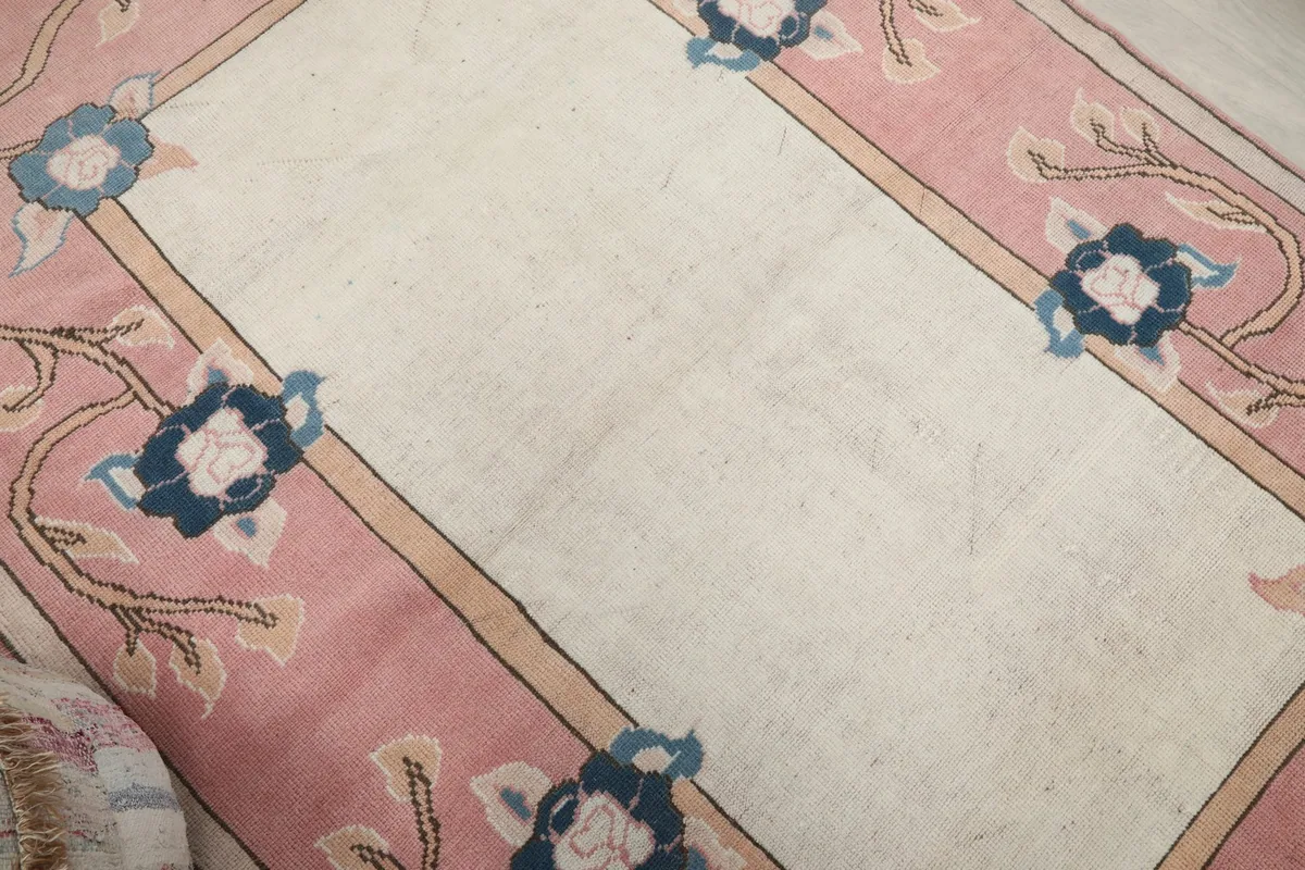 Overhead view focusing on the ivory field and a portion of the rose floral border