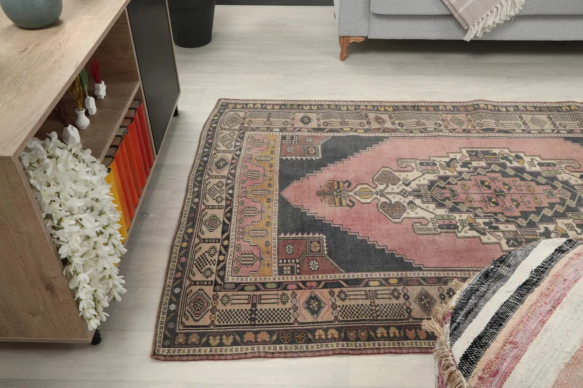 Wide angle view of the rug on the floor next to a sofa and decorative pouf