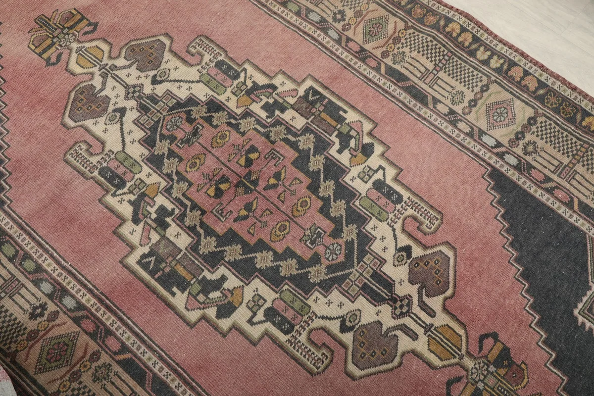 Close-up of the central geometric medallion with rose, navy, ivory, and yellow details