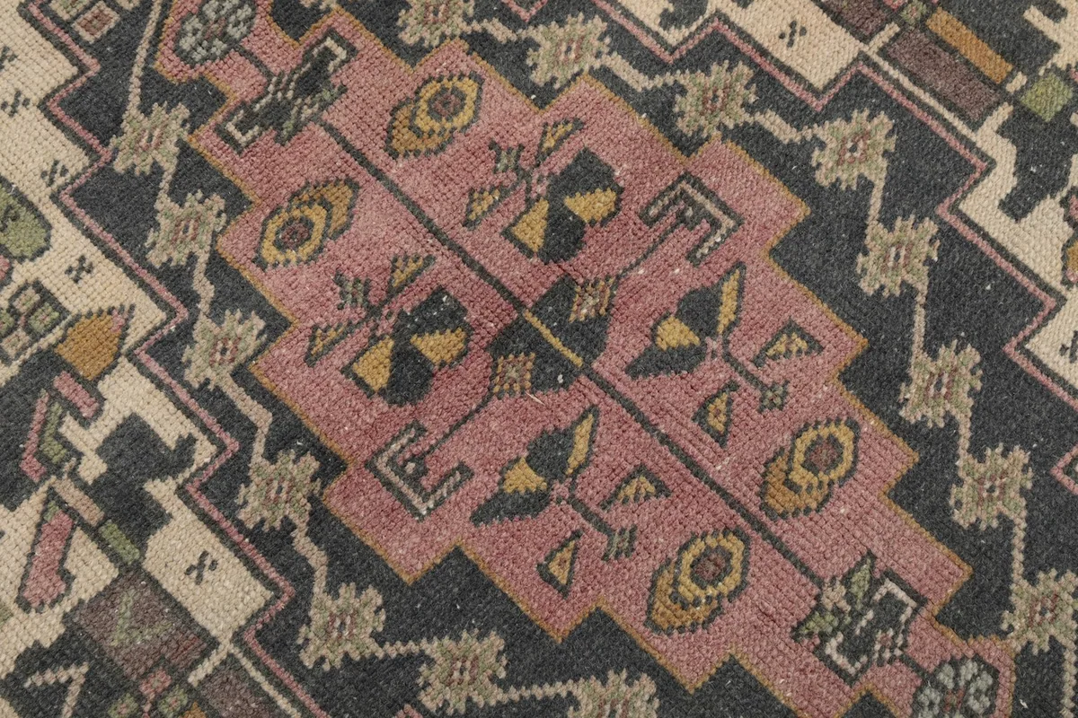 Intricate patterns within the medallion, showing faded colors and wool texture