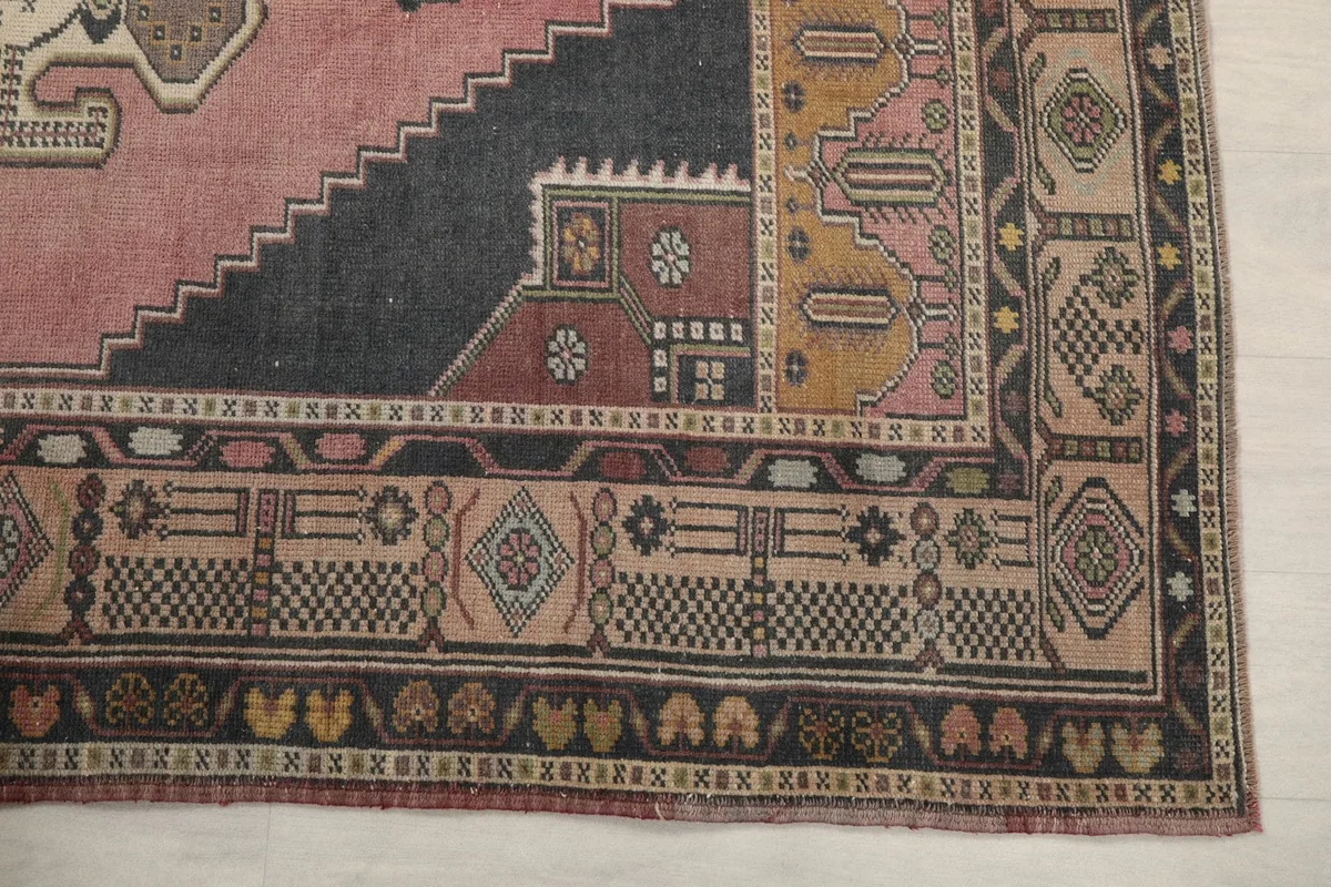 Detailed view of the complex geometric and tribal patterns in the rug's border