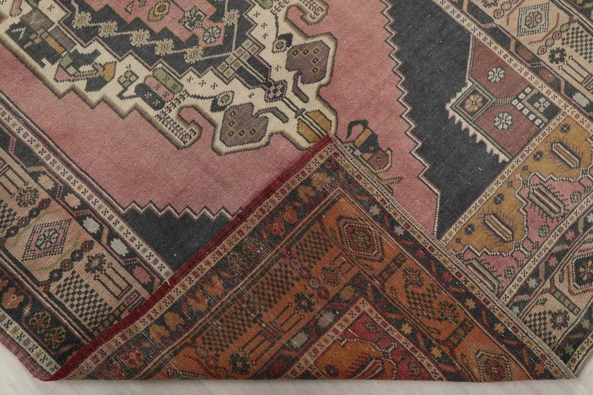 Corner of the rug folded back to reveal the hand-knotted cotton foundation
