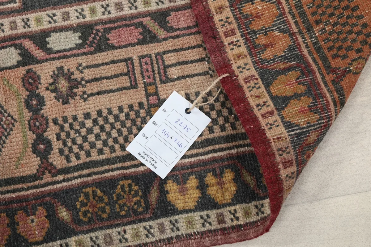 Detail of the rug with a product tag, showing the wool pile and hand-knotted construction