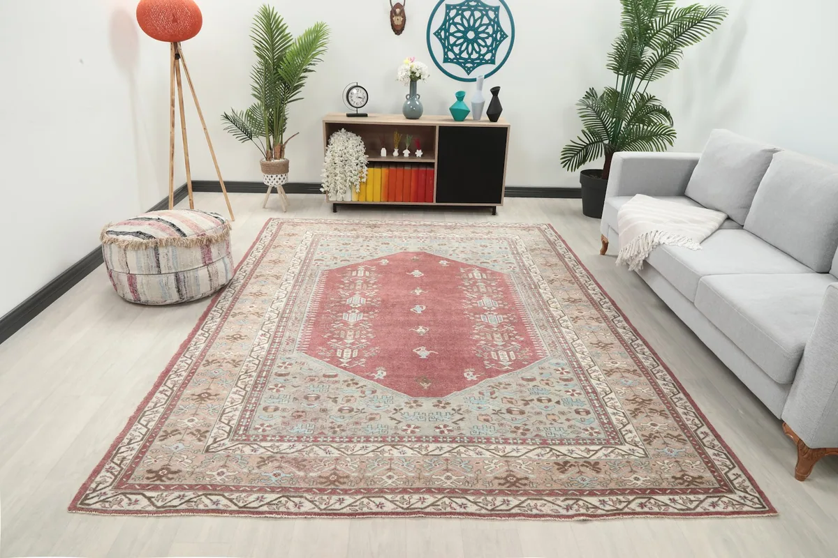 Vintage rose tribal medallion rug displayed in a living room setting with a sofa and decor