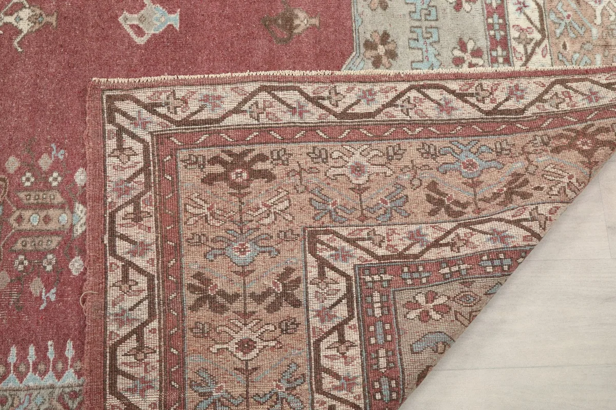 Another folded view of the rug's corner, emphasizing the hand-knotted construction and border details
