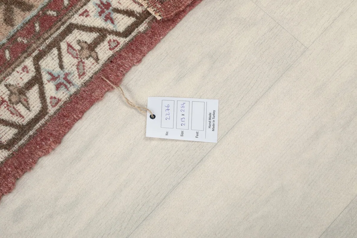 Close-up of the rug's label with size information and origin, placed on the floor