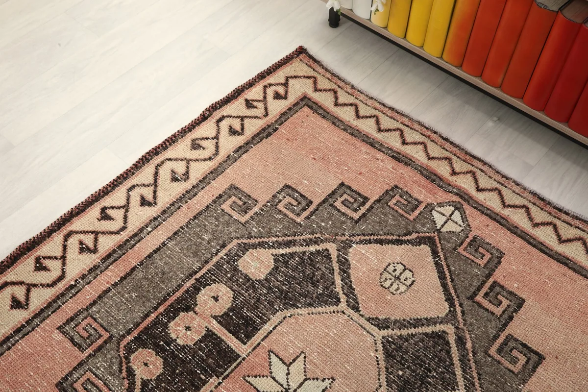 Angled view of an end of the runner rug, focusing on the border and a geometric medallion.