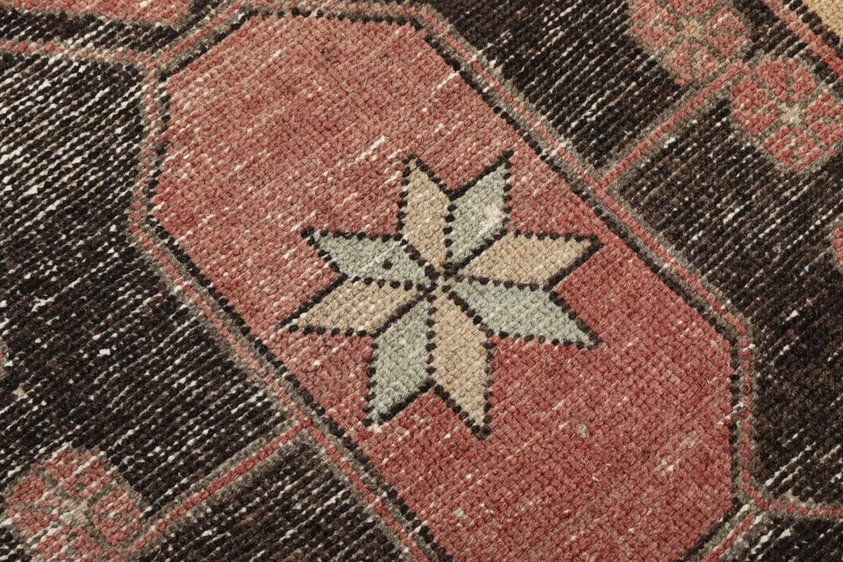 Macro detail of the star motif within a medallion, showing the subtle color variations and hand-knotted texture.