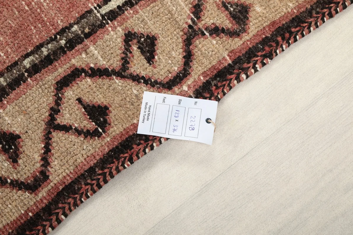 Close-up of the rug's edge with a product tag, showing the weave and texture.