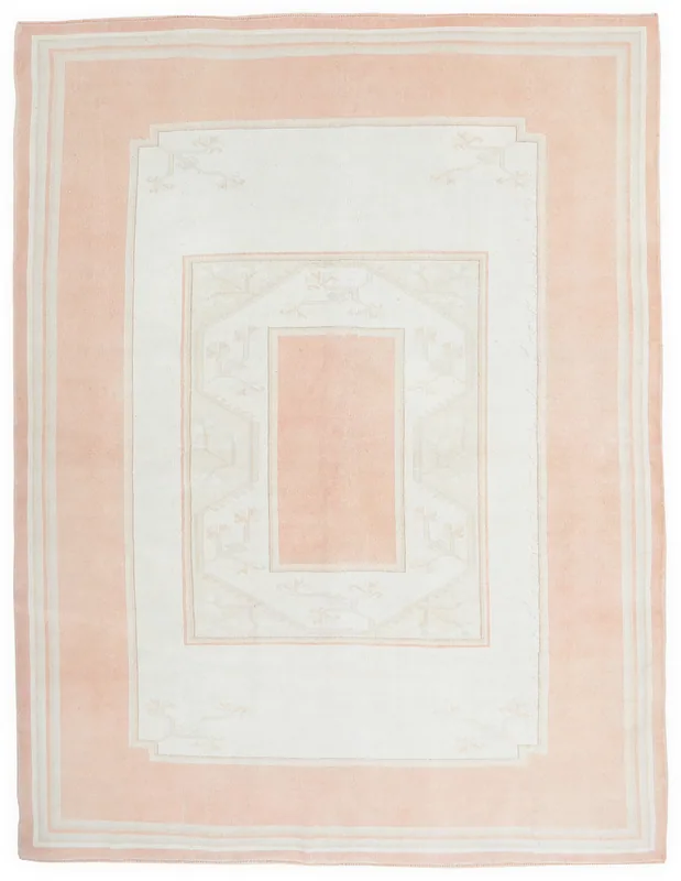Full overhead view of the pink and ivory vintage area rug on a white background