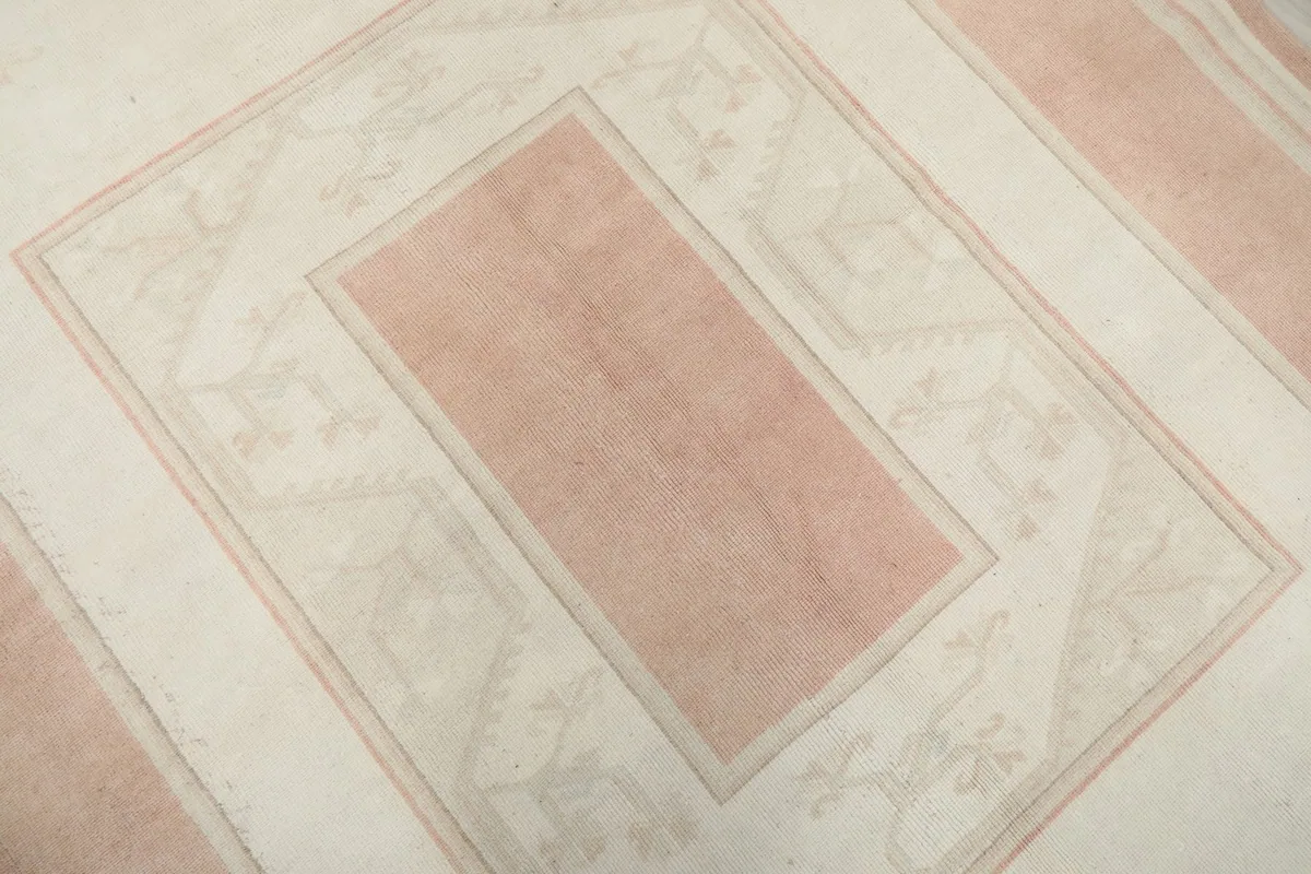 Close-up of the central pink rectangle and geometric patterns within the ivory field