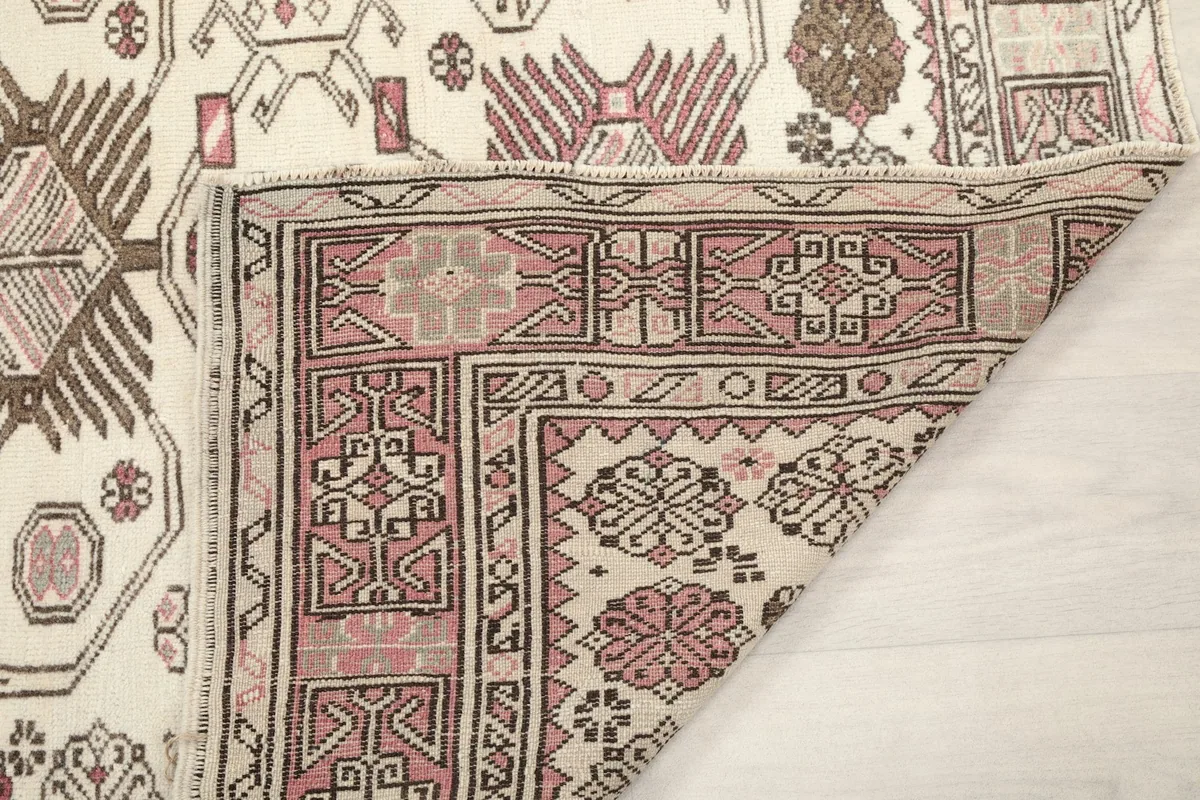 Another view of a folded corner, highlighting the reverse side of the rug's construction and color depth.