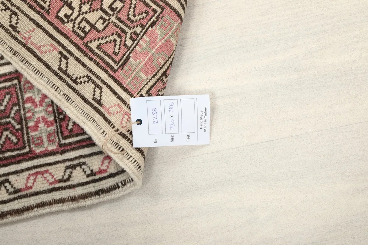 Rug corner with a product tag displaying size and material information on a white surface.