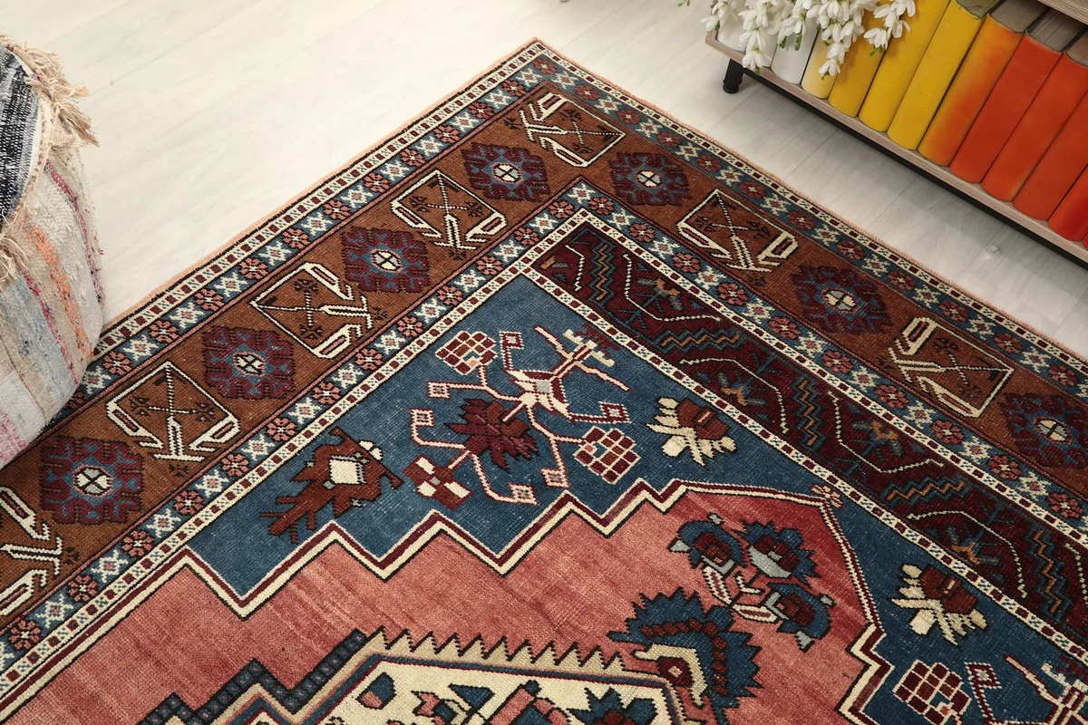 Corner view of the rug, showing the blend of rose, navy, and brown colors