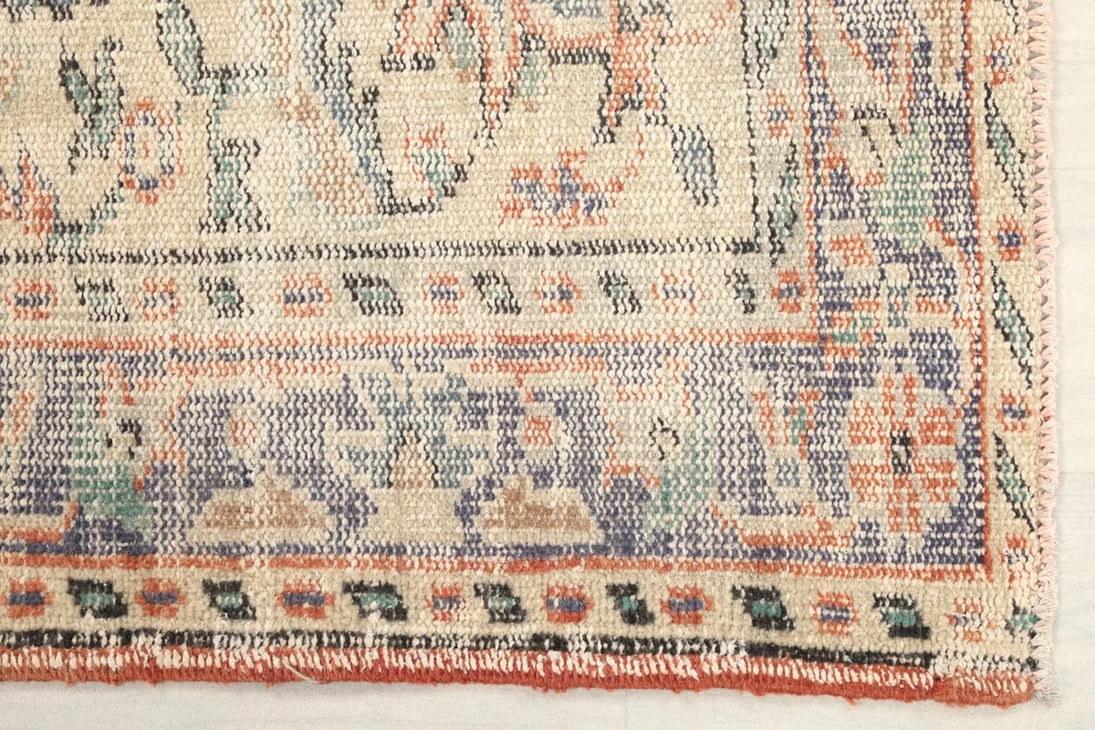 Detailed corner view of the rug, showing border patterns and color variations