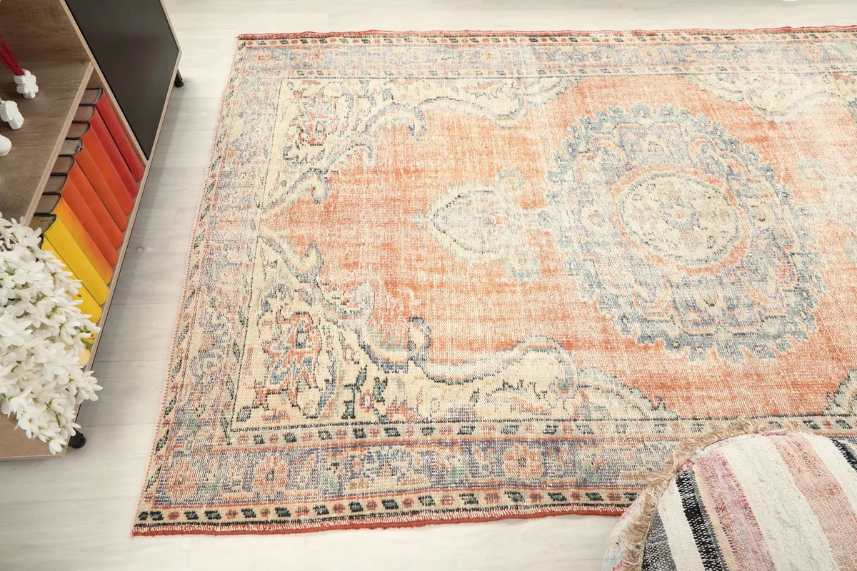 Overhead view of a section of the rug, showing the blend of orange, blue, and beige tones