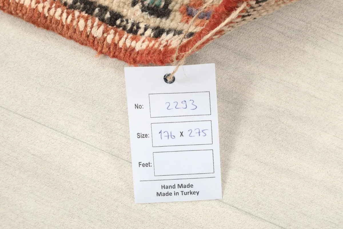 Close-up of the rug's tag, indicating its handmade origin and dimensions