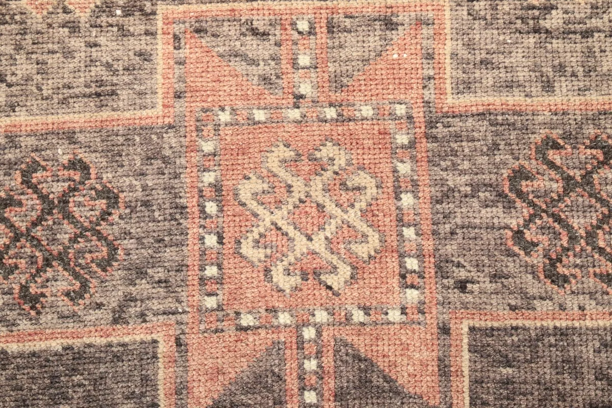 Detailed view of the intricate knotting and colors within a central geometric medallion.